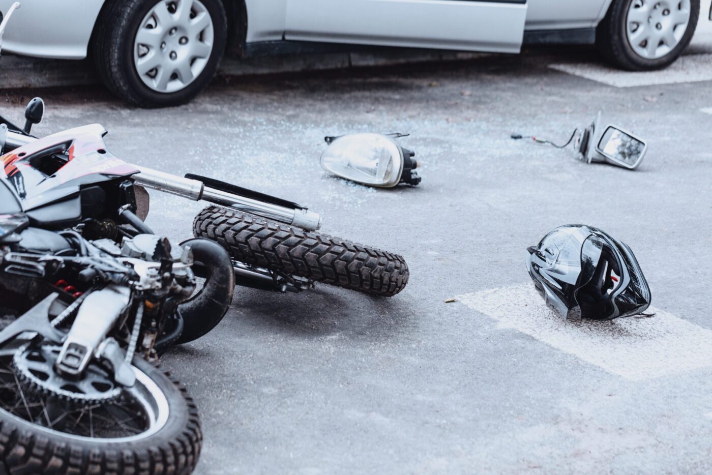 Overturned motorcycle and scattered debris on pavement, depicting the aftermath of a motorcycle accident.