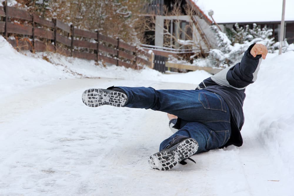 Winter hazards abound as a man slips and falls, illustrating the dangers of accidents during the colder months.







