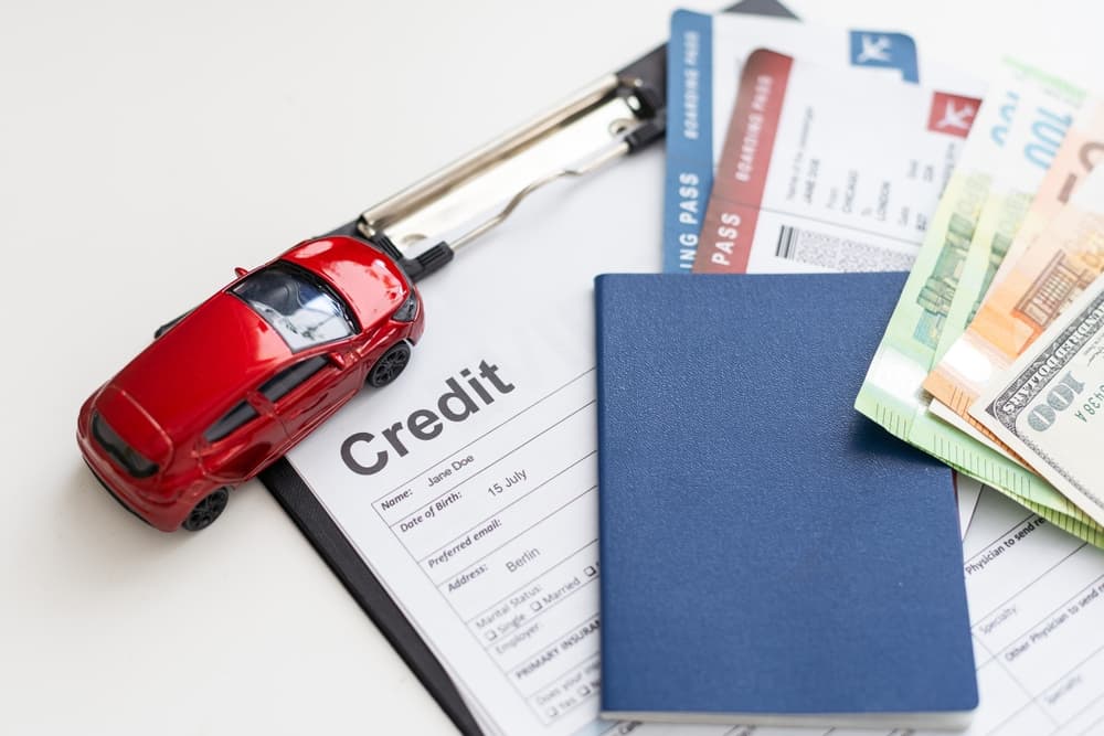 Concept of a car accident settlement involving a toy car, credit form and some money.