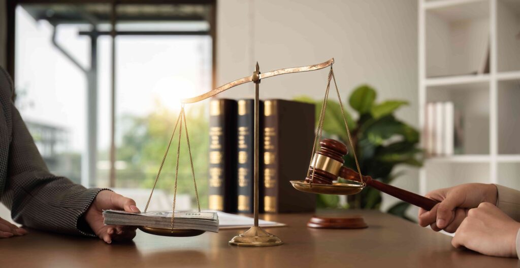 Balanza de la justicia que equilibra el mazo y la pila de dinero, simbolizando el juicio legal y el acuerdo financiero en la ley.