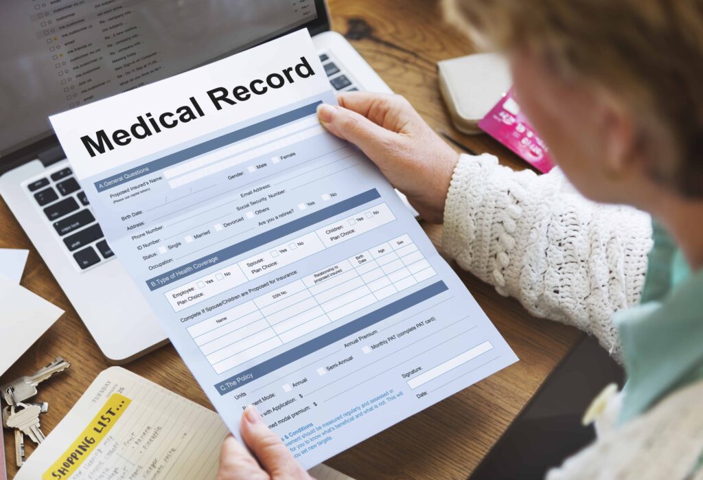 Patient reviewing medical record form on laptop at home.