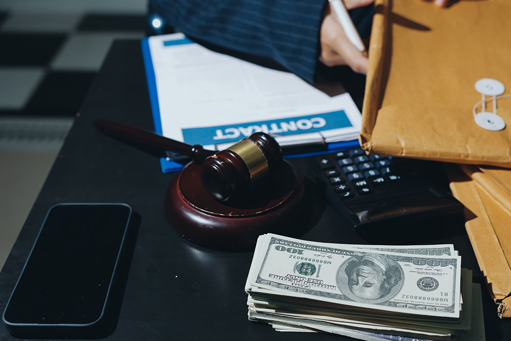 Lawyer and client reviewing contract paperwork, representing how attorney fees and case costs affect the total cost to hire a lawyer